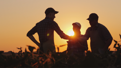 This is a picture of two men shaking hands on a farm, representing the expertise of Farmer's Association staff. The staff are product experts who can assist customers with any questions they may have about the store's wide range of farm and ranch supplies.